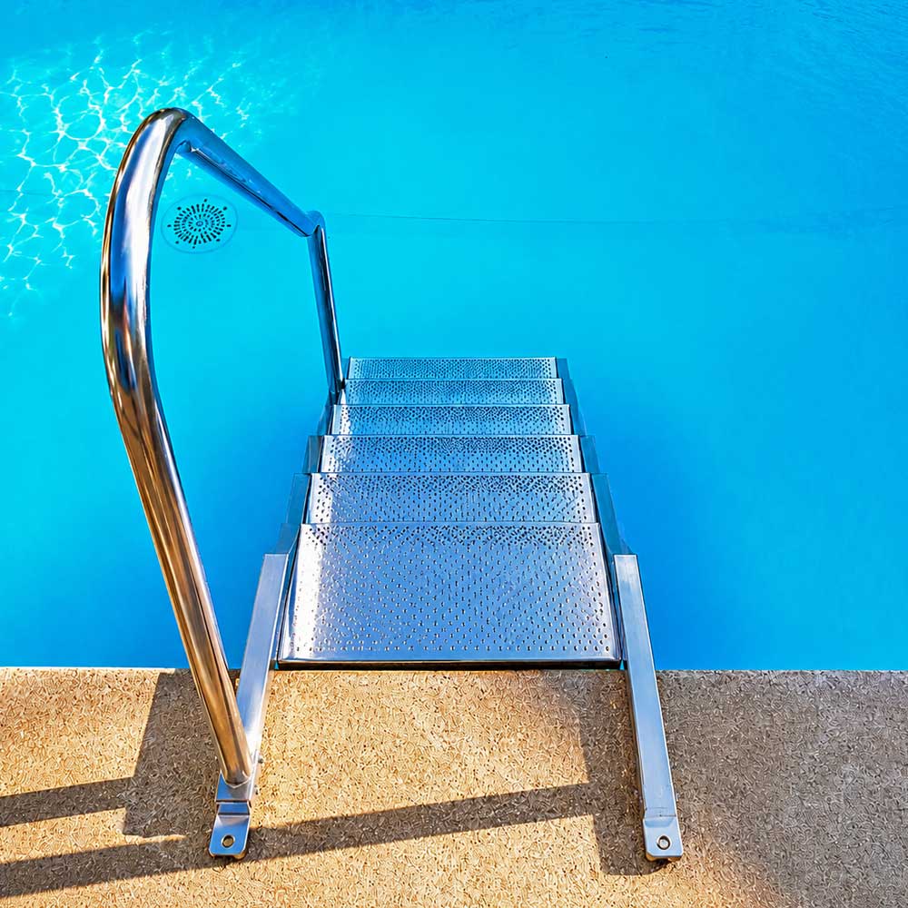 Pooltreppe aus Edelstahl V4A mit rechtsseitigem Handlauf im eingebauten Zustand am Schwimmbecken