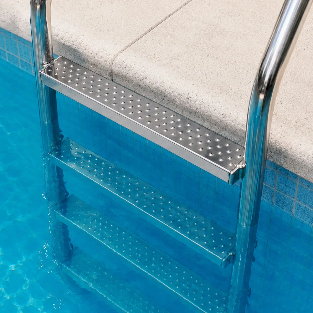 Rutschhemmende Edelstahl-Stufen montiert an einer Poolleiter mit Edelstahl-Handlauf – sicherer Ein- und Ausstieg ins Schwimmbecken durch die geprägte Anti-Rutsch-Oberfläche.